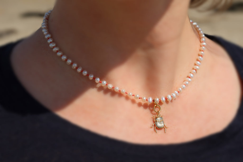 Découvrez la magie du collier scarabée en perles d'eau douce dans cette photo envoûtante. Les perles scintillantes se mêlent avec grâce, créant un spectacle de lumière éblouissant. Le pendentif scarabée, symbole mystique, attire tous les regards avec ses détails sublimes. Cette image capture l'essence même de ce bijou d'exception, offrant une invitation à l'émerveillement. Laissez-vous charmer par la beauté intemporelle de ce collier unique.